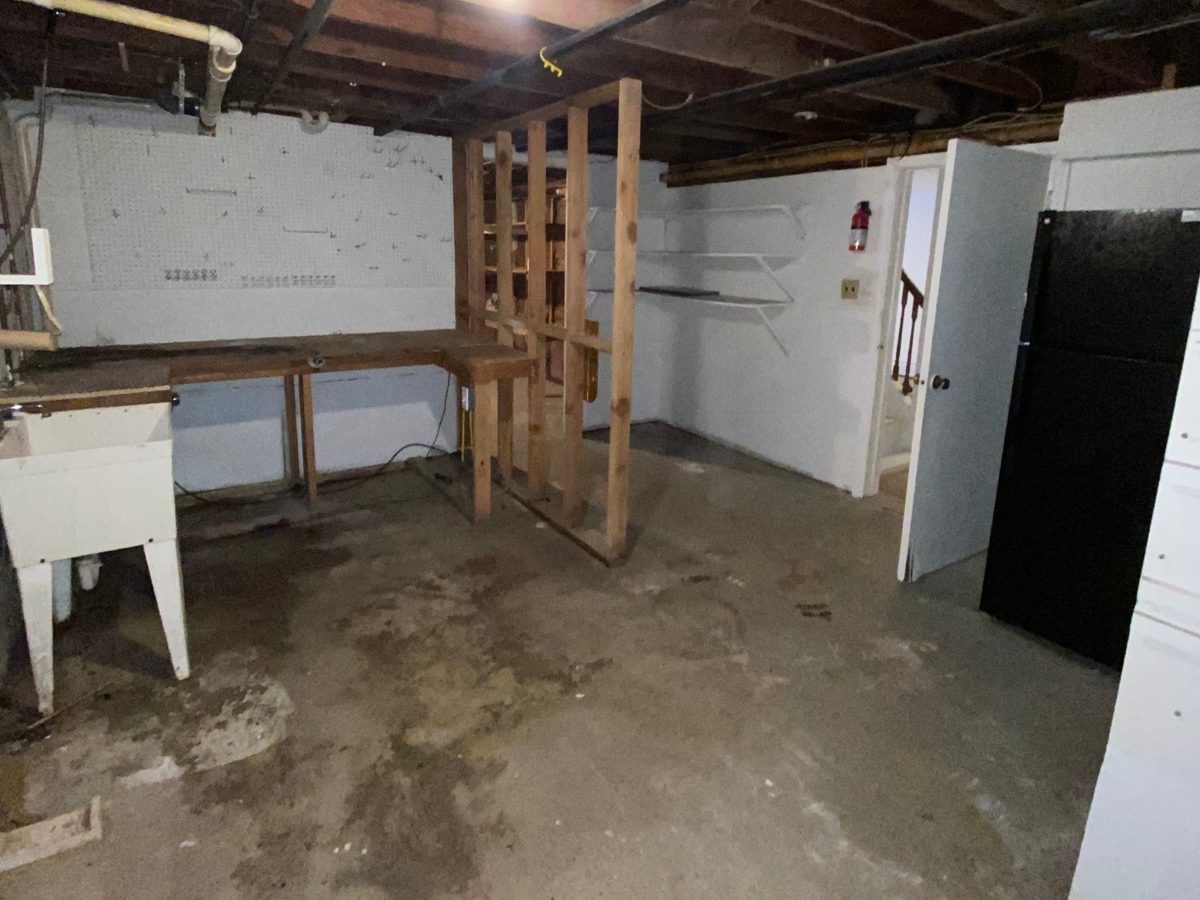Basement workshop area completely cleared out with an empty floor