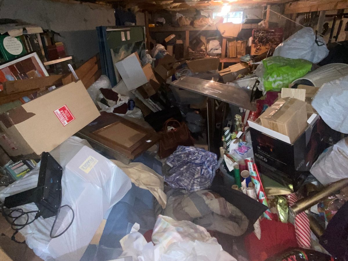 Basement packed floor to ceiling with boxes, bags, and belongings before a cleanout