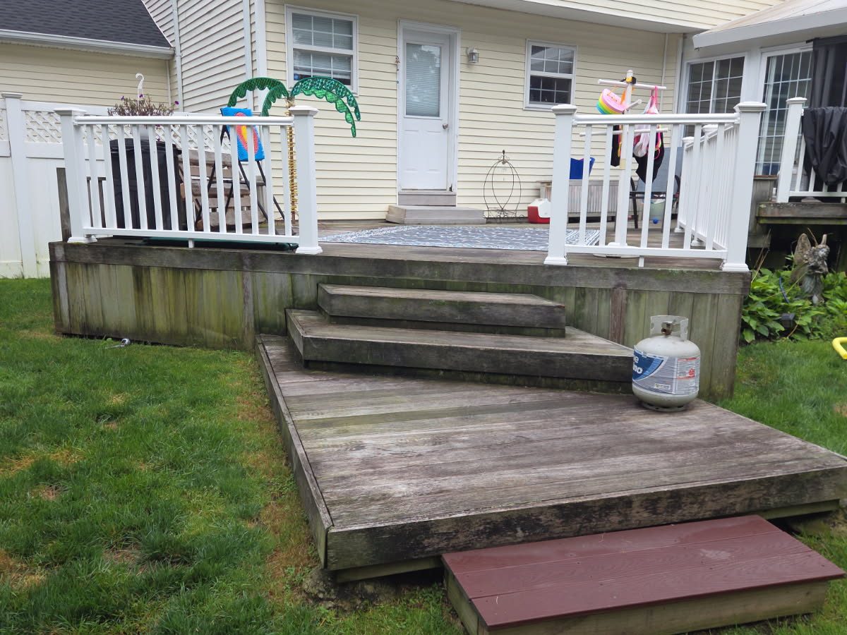 Backyard deck with stairs and white railings before removal