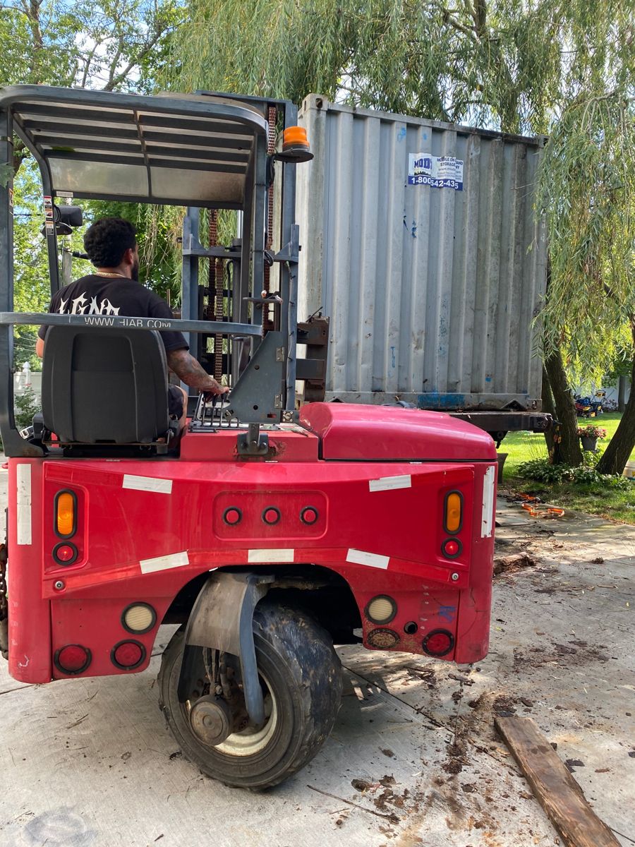 Truck-mounted forklift moving a steel storage container