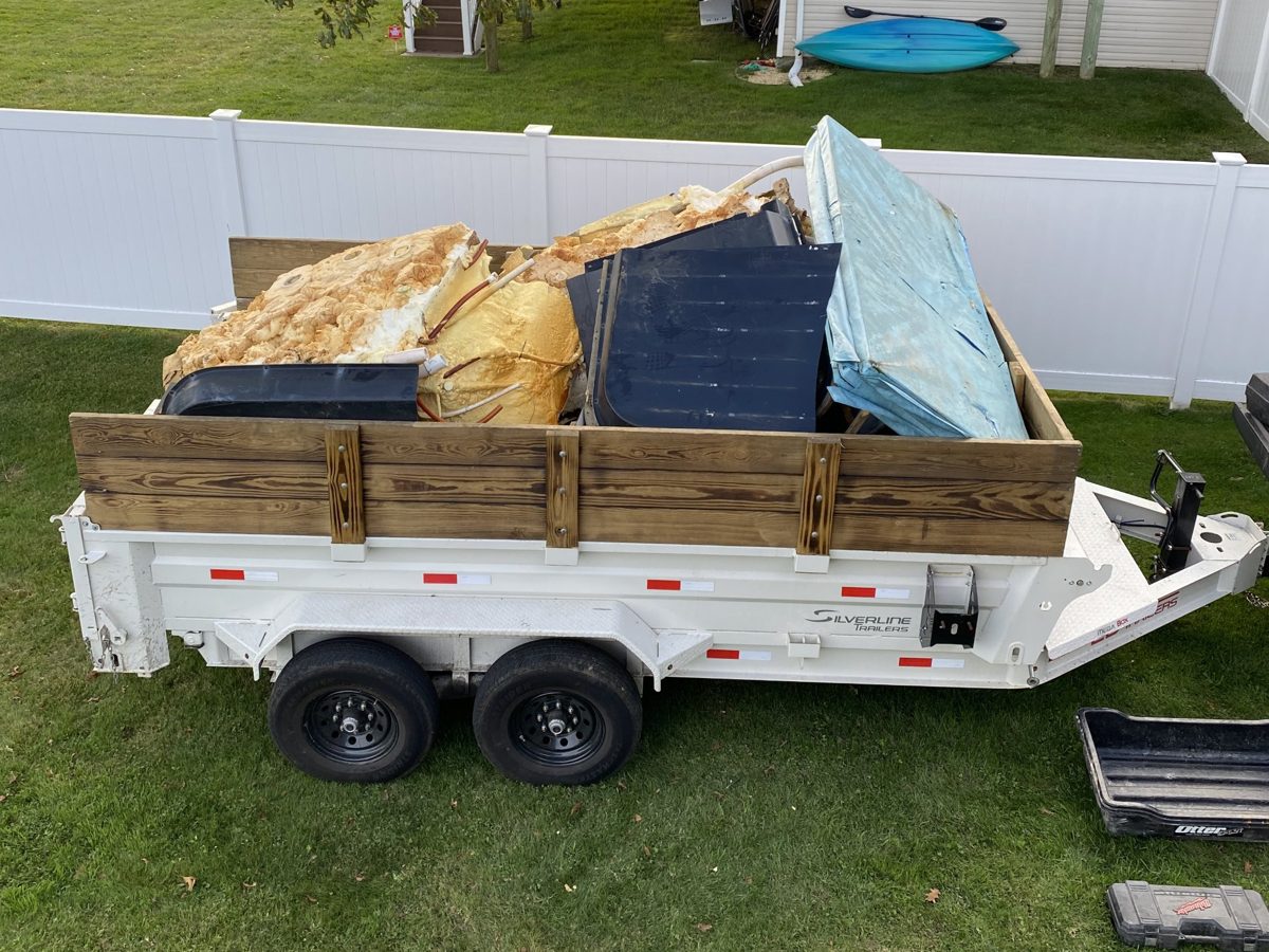Dump trailer loaded with the broken-down hot tub parts