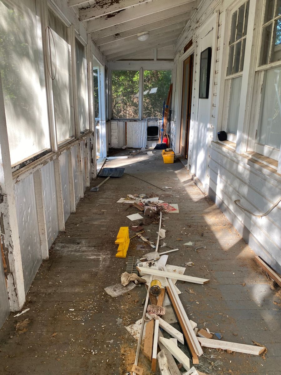 Porch mostly cleared with scattered debris left on the floor