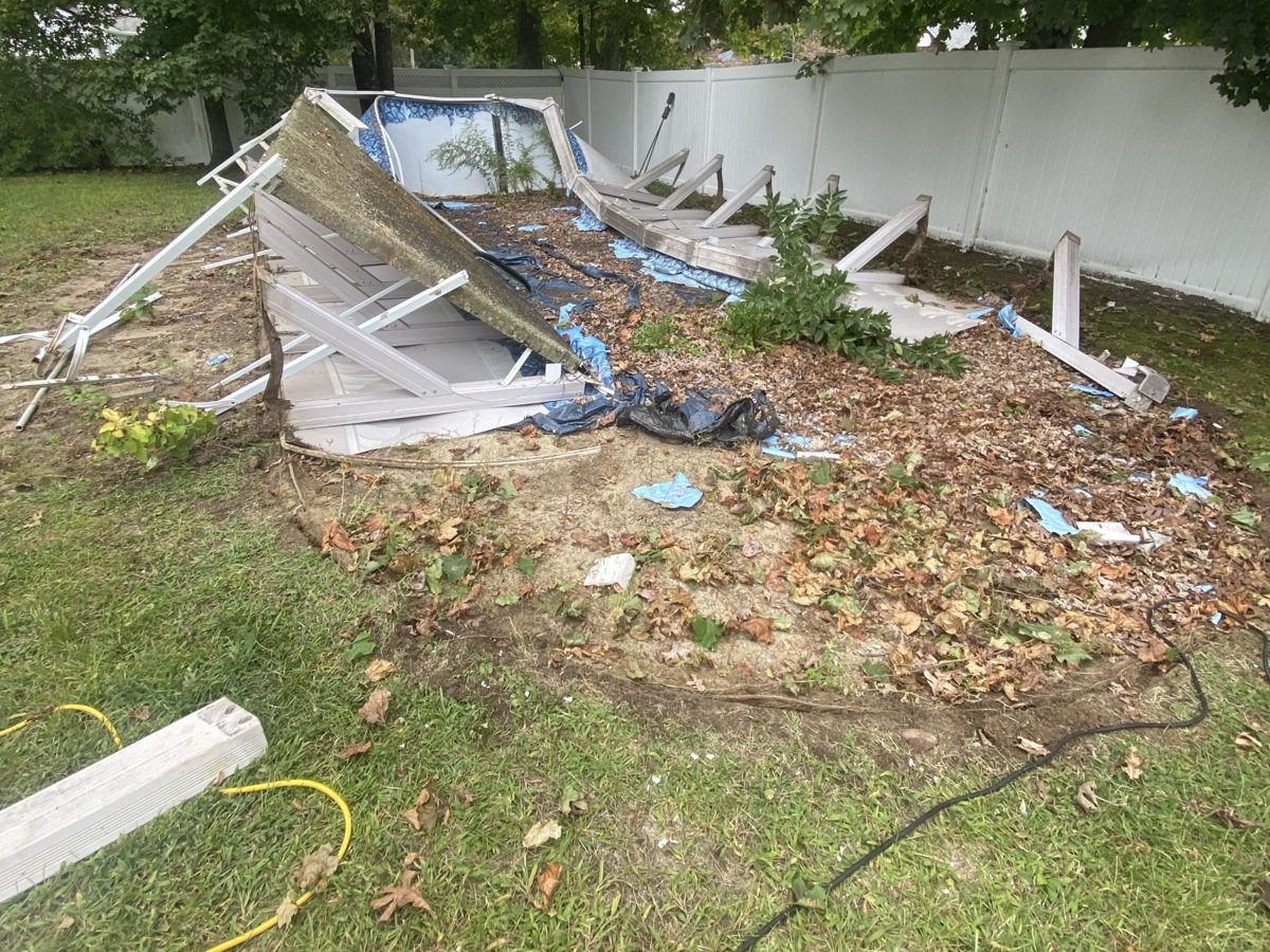 Above-ground pool collapsed and being taken apart in a backyard