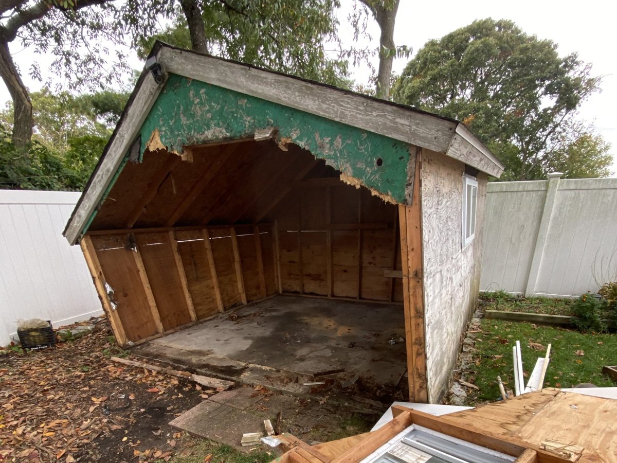 Backyard shed with the front wall and roof opened up during demolition